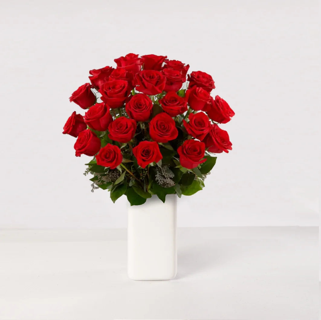 Arreglo de 24 rosas rojas en un florero