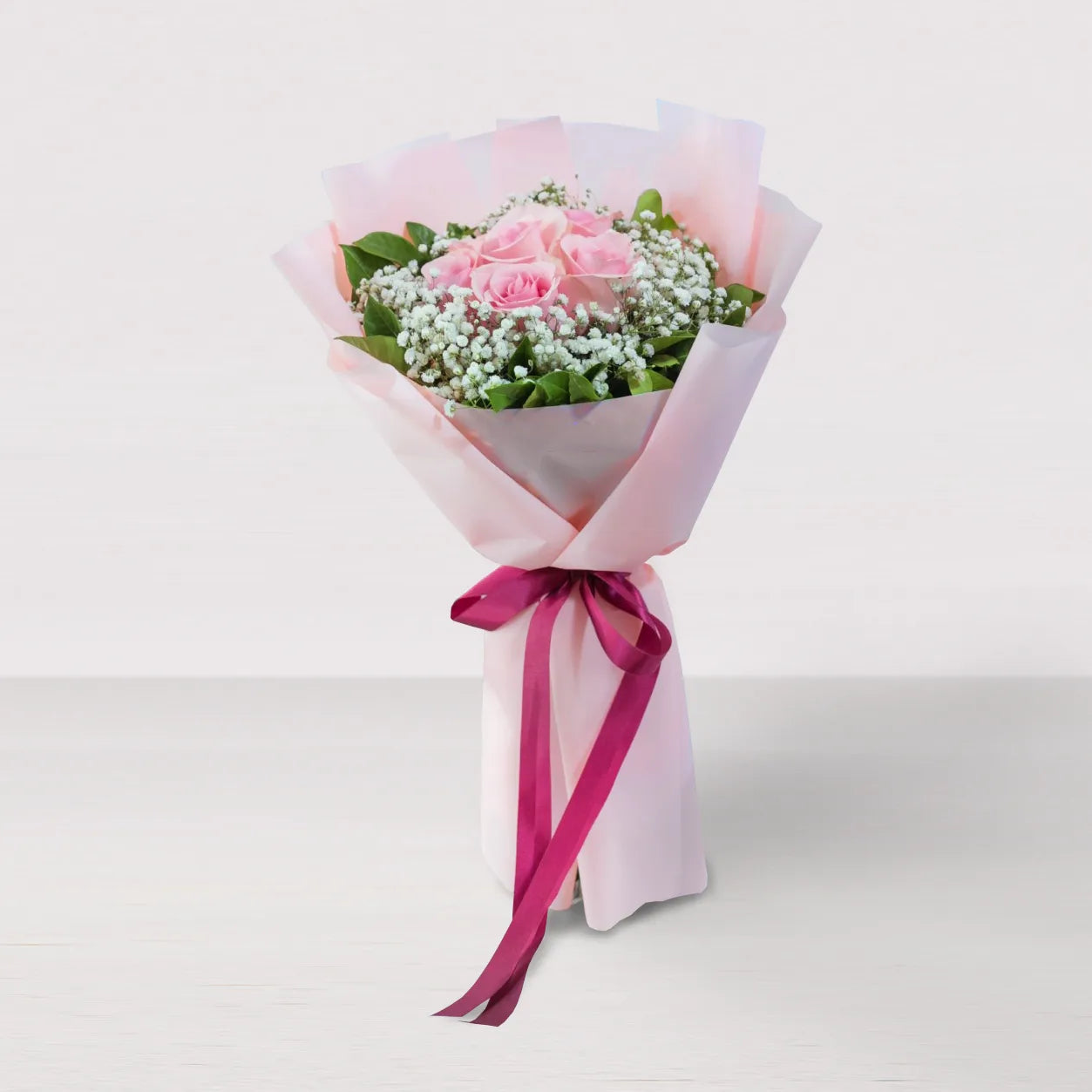 Ramo de rosas rosadas con gypsophila y moña fucsia